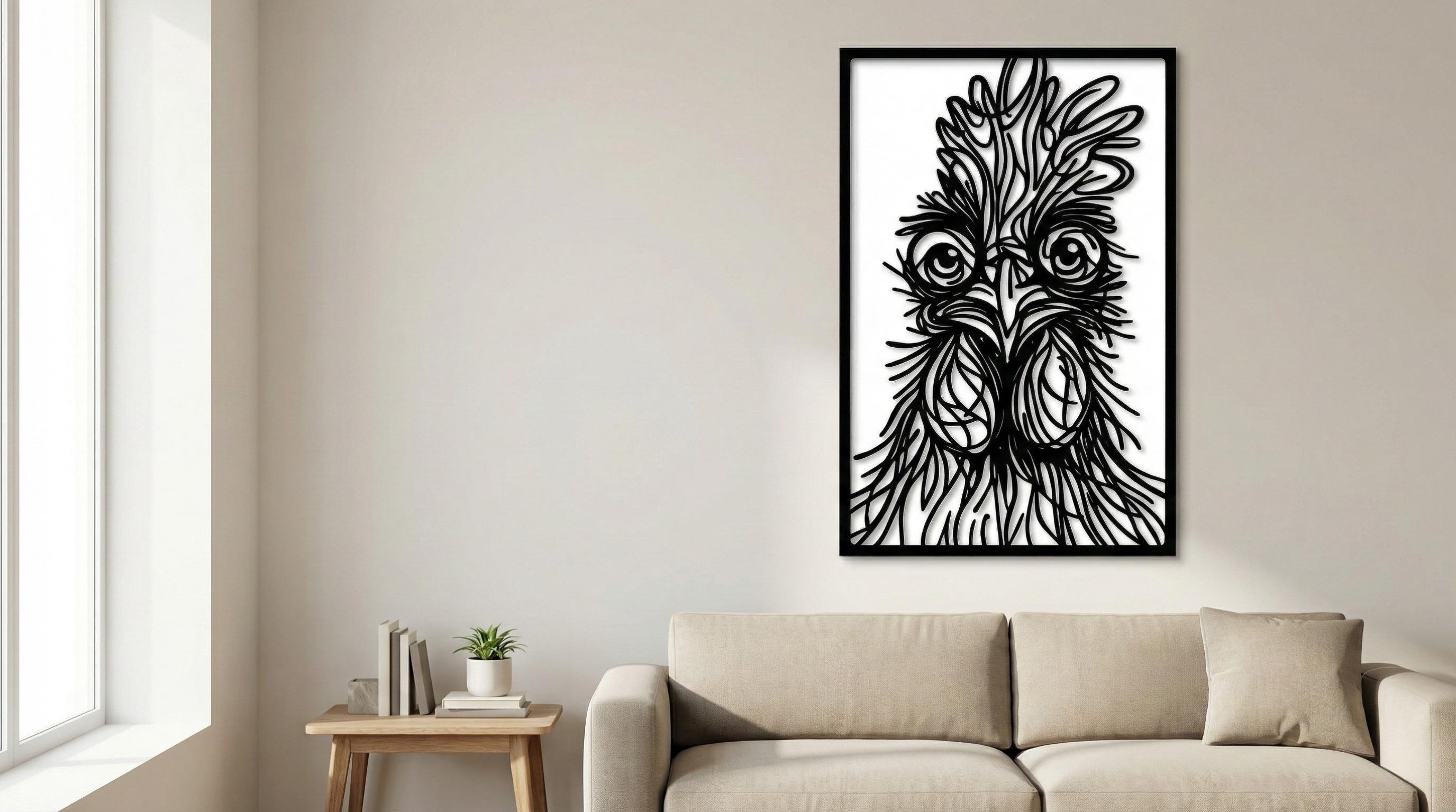 Puede incluir: Arte mural en blanco y negro que representa una cabeza de gallo estilizada. La obra de arte está enmarcada en negro y cuelga de una pared de color neutro sobre un sofá beige. Los rasgos del gallo están intrincadamente detallados.